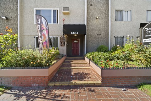 The front of a building with a red door and a sign that says "6851".