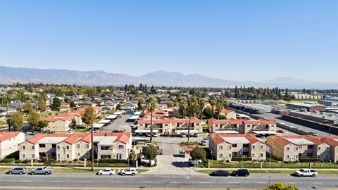 A residential area with houses and cars under a clear sky.