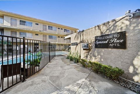 A sign that says "Welcome to Somerset Place Apts." is on a wall.