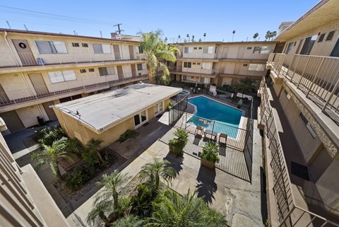 A pool in the middle of a courtyard surrounded by buildings.