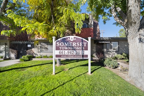A sign for Somerset Townhomes stands in a grassy area.