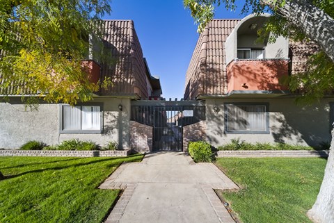 A building with a gate in the middle of a pathway.