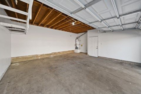 A spacious room with a concrete floor and a white door.