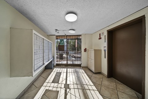 A hallway with a tiled floor and a door on the right.