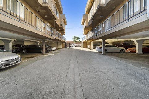 A parking lot with cars parked on both sides of the road.