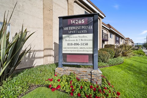 A sign for Southwest Pointe Apartments is displayed in front of a building.