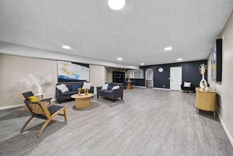 A spacious living room with a grey carpet and wooden flooring.