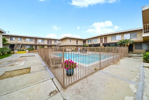 A pool surrounded by a fence with a flower pot on it.