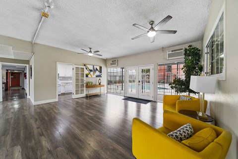 A living room with a yellow couch and a ceiling fan.
