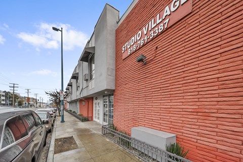 A red brick building with the words "Studio Village" on it.