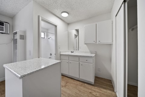 A white kitchen with a granite counter top and white cabinets.