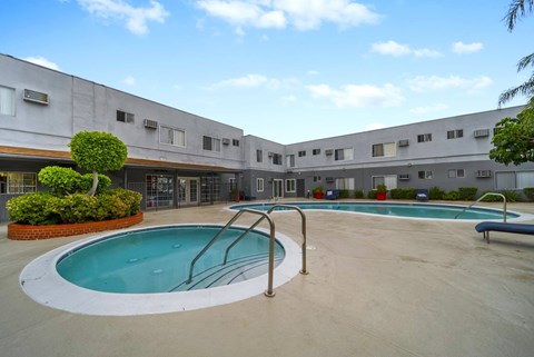 A swimming pool is surrounded by a concrete building.