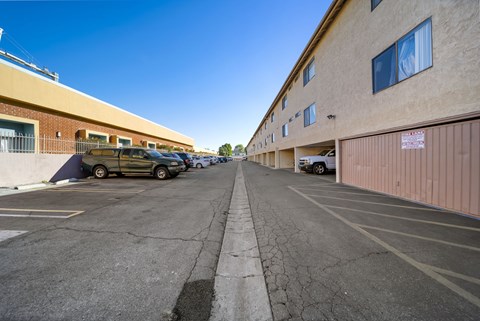A parking lot with a yellow car and a white car.
