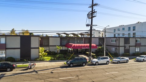 A parking lot with cars and a building in the background.