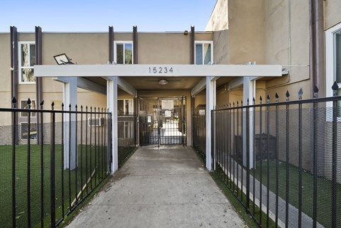 A long concrete walkway leads to a building with the number 15234 on it.