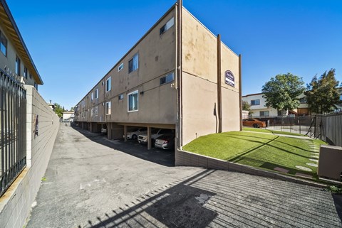 A long building with a car parked in front of it.