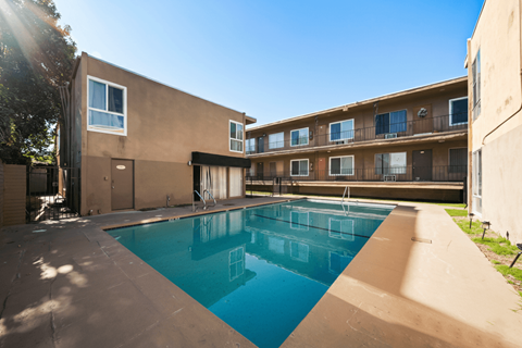 A swimming pool in a courtyard surrounded by buildings.
