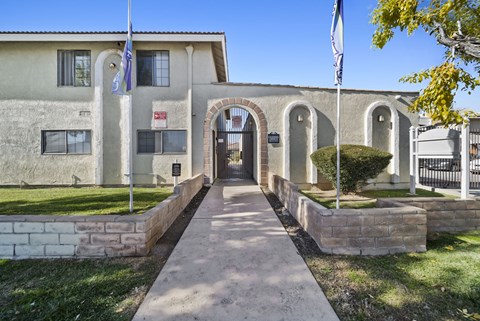 A building with a flag on top and a gate in front.