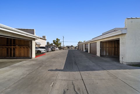 A long, empty parking lot with cars parked on the side.