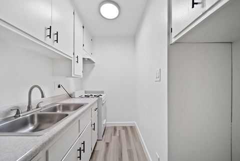 A kitchen with a sink and a stove top.