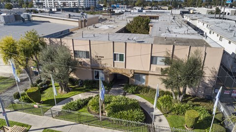 A large building with a fenced yard in front.