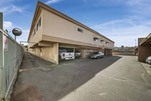 A parking lot with cars parked in front of a building.