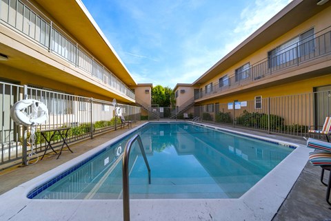 A small pool in a courtyard surrounded by buildings.