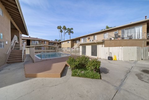 A pool area with a slide and a building in the background.
