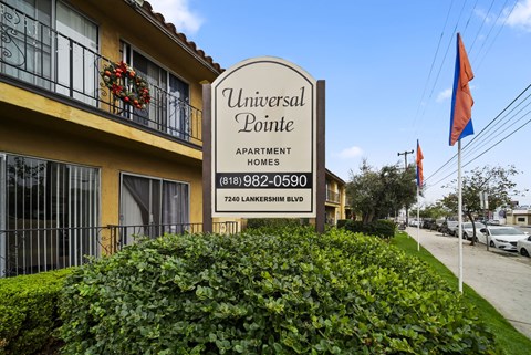 A sign for Universal Pointe Apartment Homes stands in front of a building.
