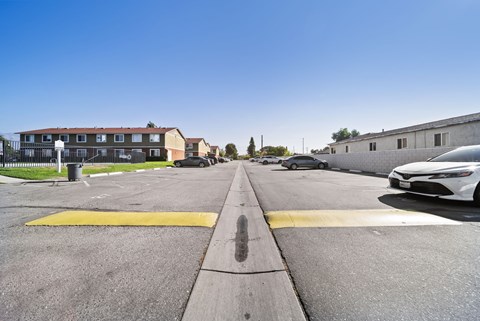 A white car is parked on the right side of a street.