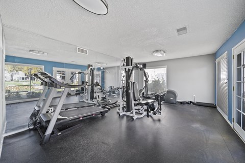 A spacious gym with treadmills, elliptical machines, and other exercise equipment.