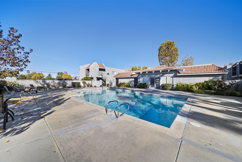 A swimming pool in a residential area with a house in the background.