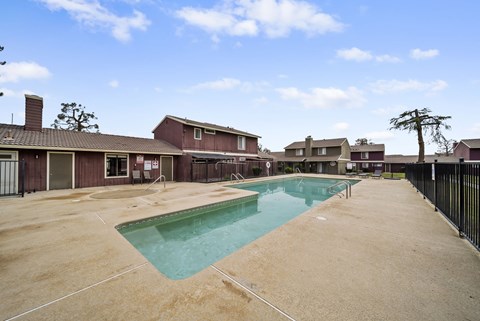 A swimming pool in a residential area surrounded by houses.