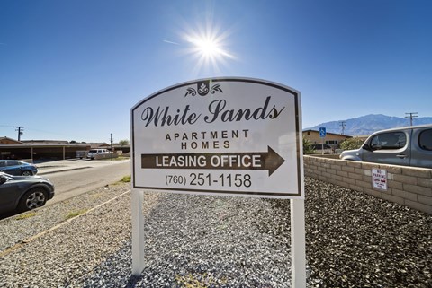 A sign for White Pands Apartment Homes with a phone number for the leasing office.