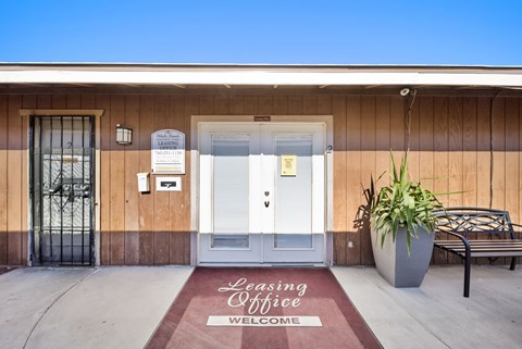A building with a Leasing Office sign on the door mat.