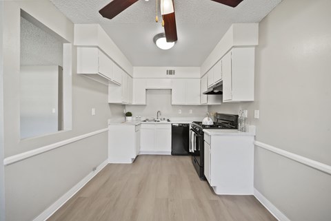 A kitchen with white cabinets and a black stove top oven.