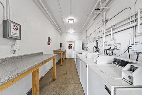 A clean, white industrial kitchen with a no smoking sign on the wall.