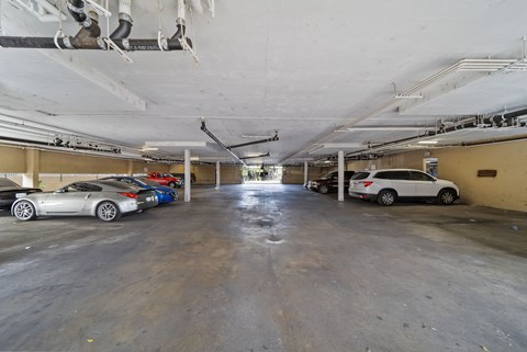 A parking garage with a white car in the foreground.