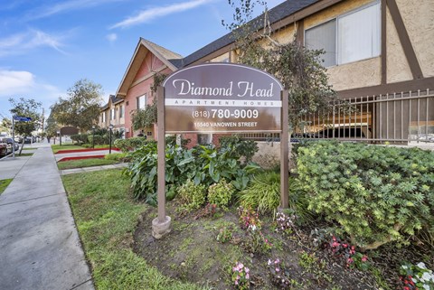 A sign for Diamond Head Apartment Homes stands in front of a building.