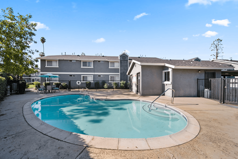 A swimming pool in a backyard with a house in the background.