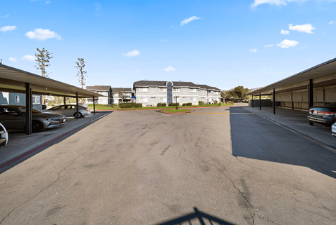 A parking lot with cars parked and a building in the background.