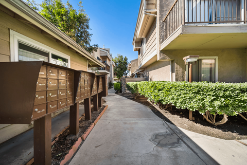 A row of houses with a concrete walkway between them.