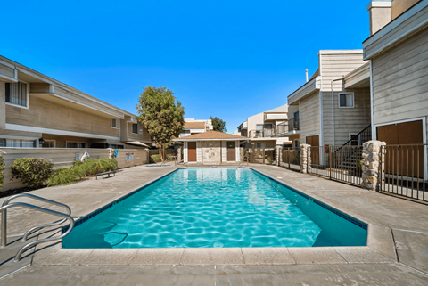 A swimming pool in a residential area surrounded by houses.