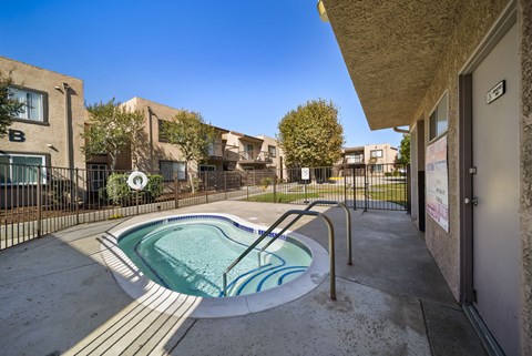 A small pool in a courtyard surrounded by buildings.