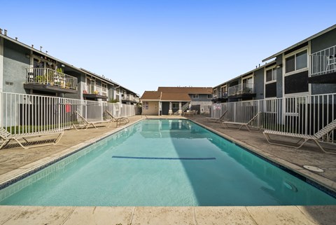 A long rectangular pool in the middle of a courtyard surrounded by buildings.