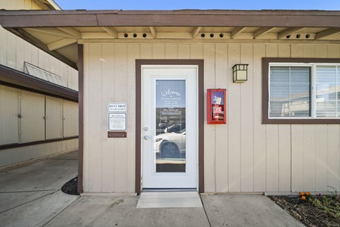 A white door with a glass window and a sign on it.