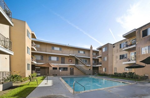 A large apartment complex with a pool in the middle.