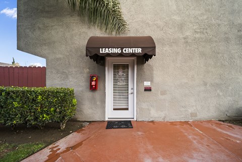A leasing center with a white door and a red fire extinguisher on the wall.