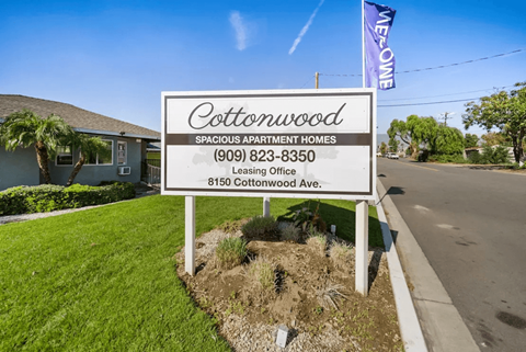 A sign for Cottonwood Spacious Apartment Homes with a leasing office at 8150 Cottonwood Ave.