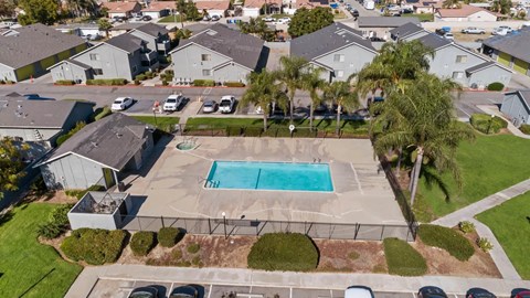 A swimming pool in a residential area surrounded by houses.